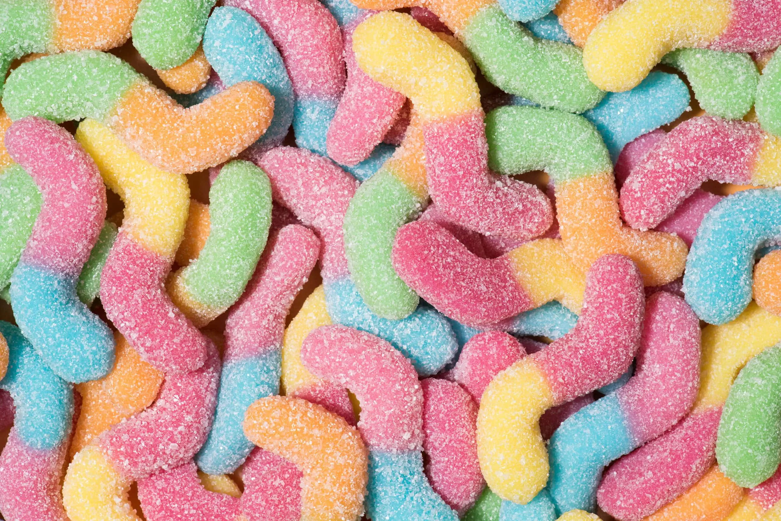 A close up of a pile of colorful HHC-R gummy worms.
