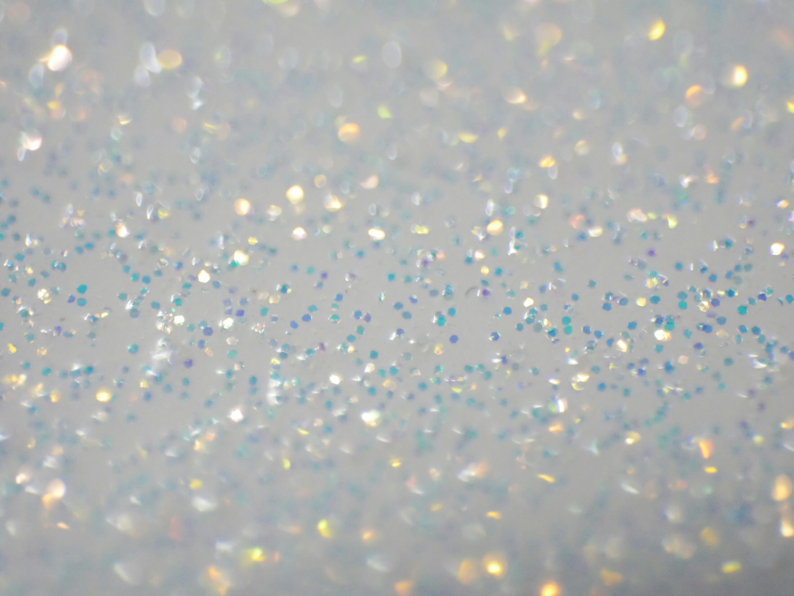 Close-up of a glittering surface with scattered blue and silver sparkles.