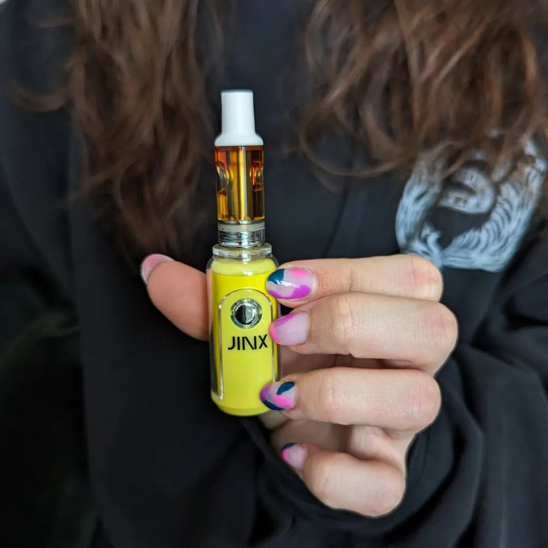 A woman holding a yellow bottle of cbd.