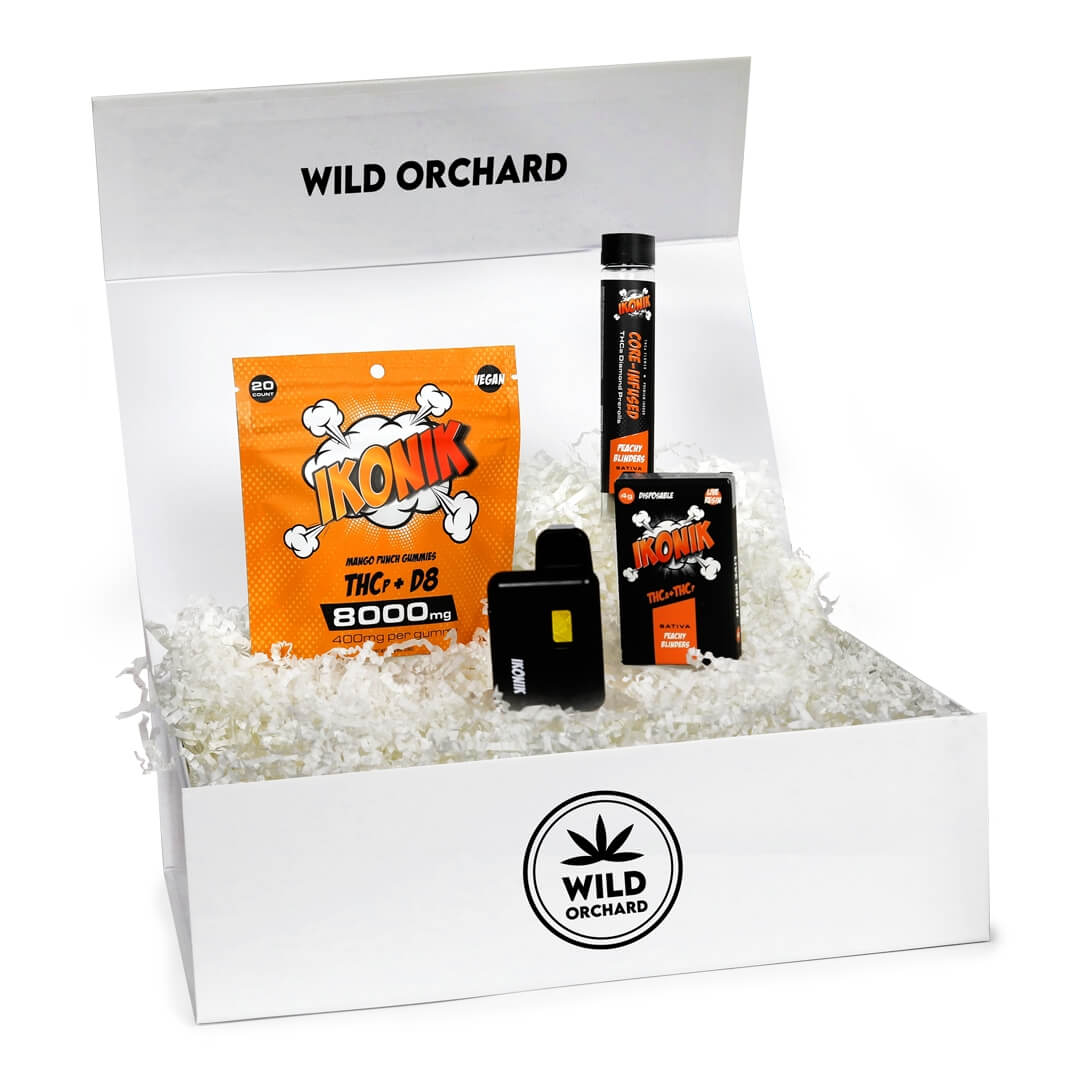 A wild orchard branded box with THC products including a vape cartridge, a disposable vape pen, and a packet, all labeled “IKONIK Bundle.”